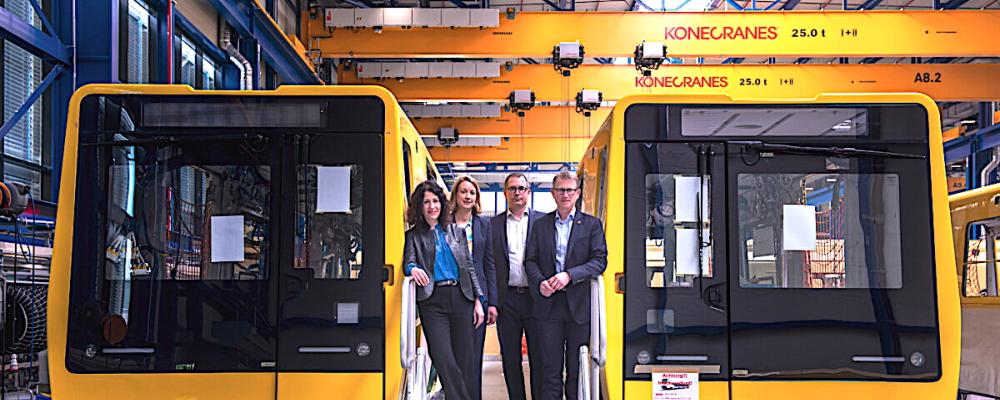 Berlins mobilitetssenator Bettina Jarasch fick vid ett platsbesök en första inblick i den nya tunnelbanan. I Stadlers monteringshall i Pankow sydväst om Berlin står för närvarande tolv gula vagnar av den nya tunnelbaneserien tätt uppställda. Totalt byggs åtta testtåg i inledningsskedet, där varje tåg består av flera vagnar. Fyra av tågen är avsedda för smalprofil och fyra för storprofil. Produktionen har inletts med smalprofilstågen, som används på linjerna U1 till U4.Vid en pressvisning av den nya generationen tunnelbanetåg. Bild: Team On.