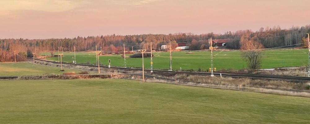 Järnvägsspår som löper genom ett öppet jordbrukslandskap Västra Götaland. Foto: Stina Wickenberg