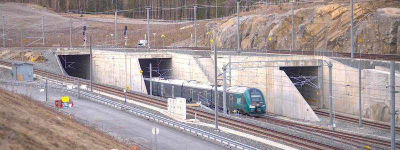 Ett tåg av class 75 kommer in i Blixtunnelns södra portal på Follobanan vid Ski. De två tunnlarna till vänster är Blixtunneln, där det mesta av Follobanan går in. Tunneln längst till höger är Roåstunneln, där spåret leder till Østfoldbanan. Foto: Wikipedia Common, kredit: Stylez995