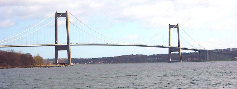 Det finns två broar i Danmark som heter Lilla Bältbron. Det är en äldre från 1935 och en nyare från 1970 (i bilden). Båda broarna går över Lilla Bält mellan Snoghøj (numera en del av Fredericias tätort) på Jylland och Middelfart på Fyn. Den nyare bron är en ren vägbro och vägen utgörs av en viktig motorväg. Foto: Wikipedia Commons. Kredit: Kredit:  Ävar Arnfjöro Bjarmason.