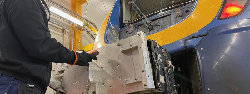 Linus Andersson på Euromaint provmonterar den nya prototypen på ett X62 Coriadia Nordic. Foto: Norrtåg
