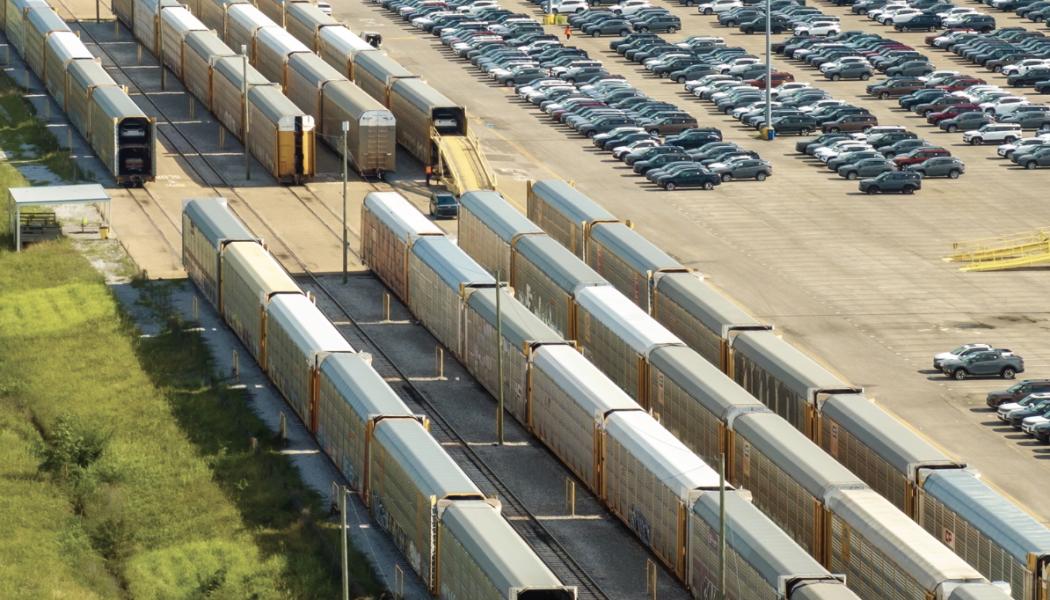 Nya bilar lastas på biltransportvagnar vid bilfabrikens parkeringsplats. Foto: INPS Group