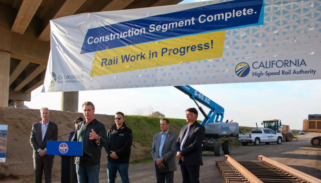 Guvernör Gavin Newsom anslöt sig till VD:n för California High-Speed Rail Authority, Ian Choudri, lokala ledare och arbetare strax utanför Bakersfield nyligen för att inviga den nya järnvägsdepån – det första steget för att lägga spår. Guvernör Newsom, Choudri och lokala ledare markerade starten med en symbolisk spik och firade samtidigt det omfattande slutförandet av Byggpaket 4 (CP 4) – den sydligaste delen av den initiala driftslinjen för höghastighetståget. Foto: California High-Speed Rail Authority