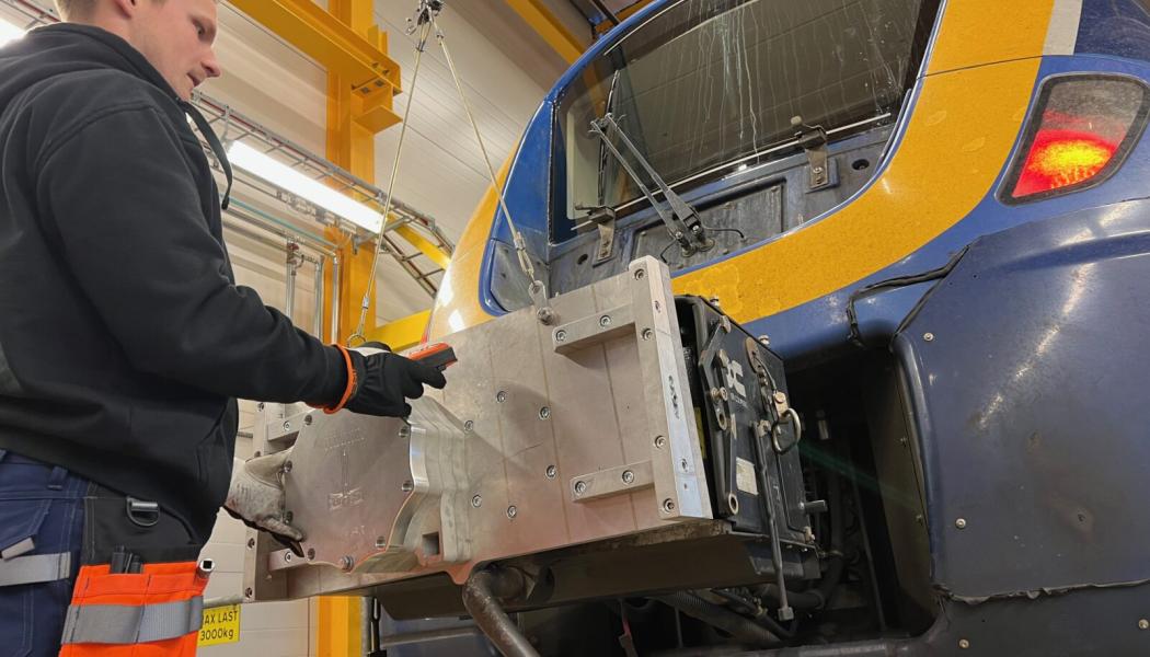 Linus Andersson på Euromaint provmonterar den nya prototypen på ett X62 Coriadia Nordic. Foto: Norrtåg