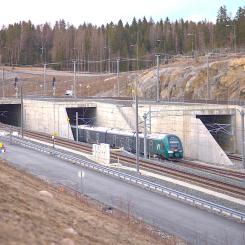 Ett tåg av class 75 kommer in i Blixtunnelns södra portal på Follobanan vid Ski. De två tunnlarna till vänster är Blixtunneln, där det mesta av Follobanan går in. Tunneln längst till höger är Roåstunneln, där spåret leder till Østfoldbanan. Foto: Wikipedia Common, kredit: Stylez995