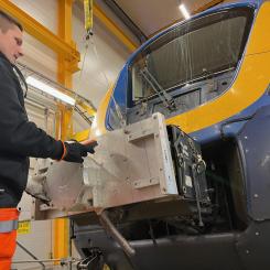 Linus Andersson på Euromaint provmonterar den nya prototypen på ett X62 Coriadia Nordic. Foto: Norrtåg